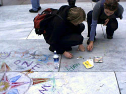 Two activists drawing compass roses on the ground.